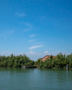 Torcello, Venedik, Ita adası yakınlarındaki ağaçların arkasındaki evde.