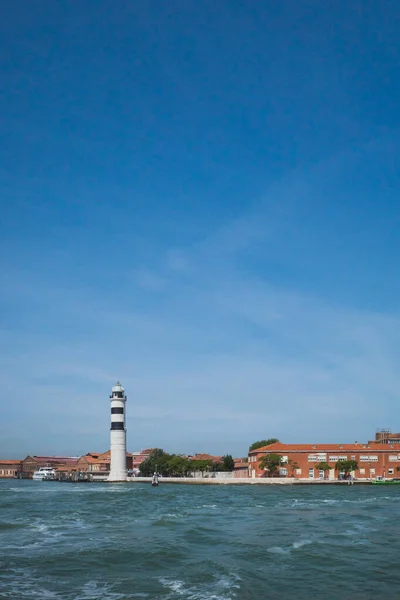 Faro y edificios por el agua, en Murano, Venecia, Italia — Foto de Stock
