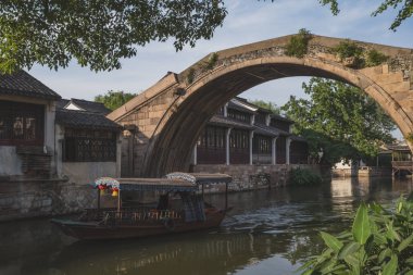Geleneksel tekne Nanxun Old köprüsünün altında nehir boyunca ilerliyor.