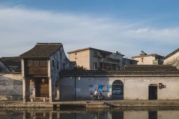 Lokale man rijden motorfiets langs traditionele architectuur in Nan — Stockfoto