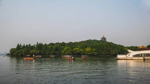 Boats over water with Leifeng Pagoda over hill, in West Lake, Ha — Stock Photo, Image