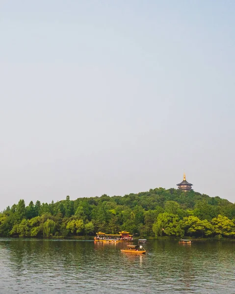 Bateaux sur l'eau avec la pagode Leifeng sur la colline, dans West Lake, Ha — Photo