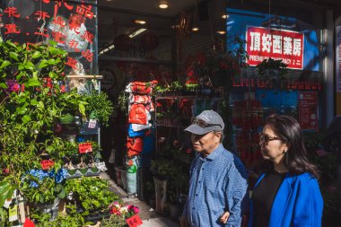 Flushing, New York City - 24 Nisan 2019: Flushing Chinatown 'daki çiçekçinin önünden geçen Asyalı çift