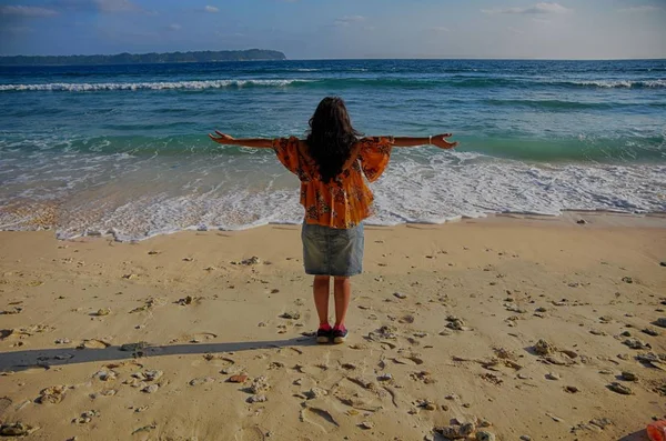 Rückansicht einer Indianerin, die sich am Strand entspannt Stockbild
