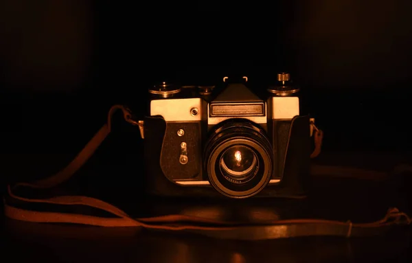 Low key image of Antique camera, camera is kept over wooden table and photographed in dark background
