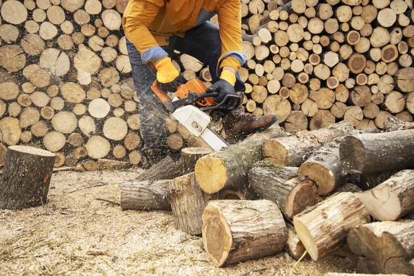 Sierra de cadena en acción cortando madera. Hombre cortando madera con sierra, polvo — Foto de Stock