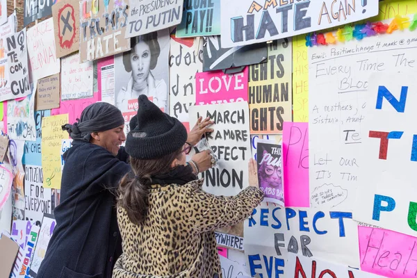 Activistas grapan afiches de protesta en la pared — Foto de Stock