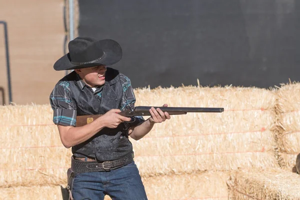 Deelnemer gekleed in periode cowboy kostuum, uitbeelden van gunfig — Stockfoto