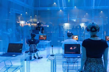 İnsanlar bir sanal gerçeklik oyunu oynamak için ekipman kullanın