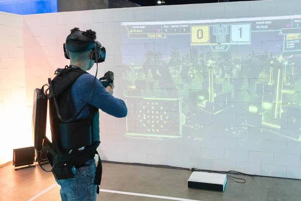 Um homem joga um jogo de vídeo usando óculos de realidade virtual — Fotografia de Stock