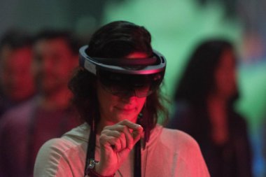 Bir kadın sanal gerçeklik gözlükle bir video oyunu oynar