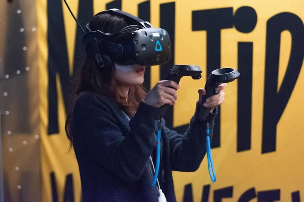 Une femme joue à un jeu vidéo en utilisant des lunettes de réalité virtuelle — Photo