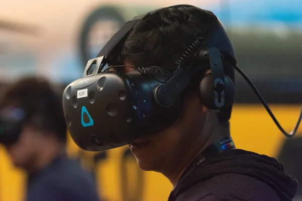 Um homem joga um jogo de vídeo usando óculos de realidade virtual — Fotografia de Stock