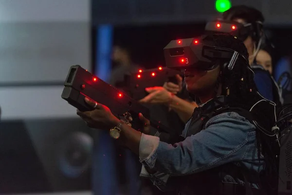 Uma mulher joga um jogo de vídeo usando óculos de realidade virtual — Fotografia de Stock