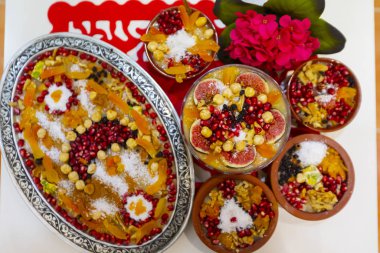 Geleneksel Tatlı Asure, Ashura, tahta tabakta Nuh 'un Pudingi. Yukarıdan yarı görünüm ve İtalyanca yazı tipi: Ashura Günü, Türkçe.