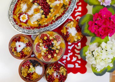 Geleneksel Tatlı Asure, Ashura, tahta tabakta Nuh 'un Pudingi. Yukarıdan yarı görünüm ve İtalyanca yazı tipi: Ashura Günü, Türkçe.