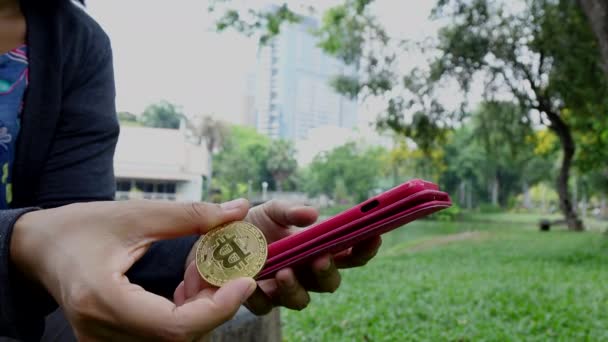 Χρησιμοποιώντας Ένα Smartphone Ένα Χέρι Και Κρατώντας Ένα Νόμισμα Bitcoin — Αρχείο Βίντεο