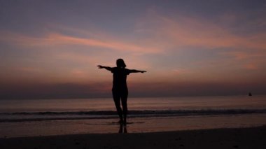 Gün doğumunda kumsalda dinlenen kadınların silueti.