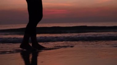 Gün doğumunda kumsalda dinlenen kadınların silueti.