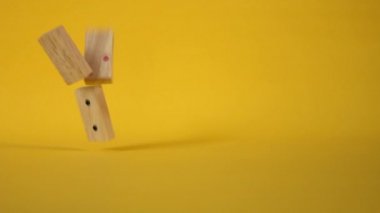 Sarı arkaplana düşen domino taşlarının yavaş hareketi