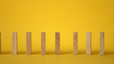 Sarı arkaplana düşen domino taşlarının yavaş hareketi