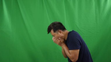 Asyalı adam yeşil ekranda hapşırıyor