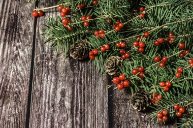 Ahşap masanın üzerinde süslenmiş noel ağacı dalı