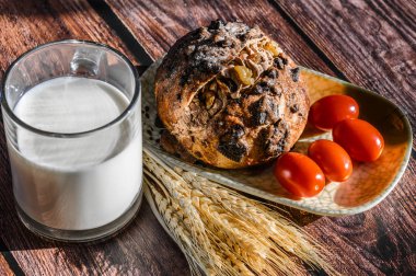 Tahta bir masada kahvaltı sandviç, kırmızı böğürtlen ve bir bardak süt. 