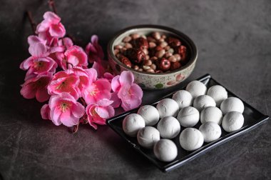 Tangyuan, peanuts, red dates and flowers on the table