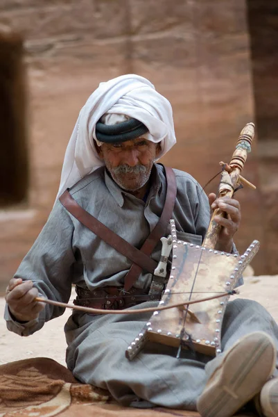 Petra, Jordan. Homem beduíno tocando instrumento tradicional — Fotografia de Stock