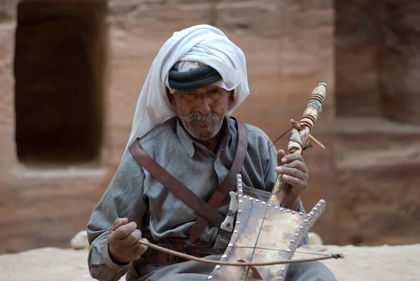 Petra, Jordan. Homem beduíno tocando instrumento tradicional — Fotografia de Stock