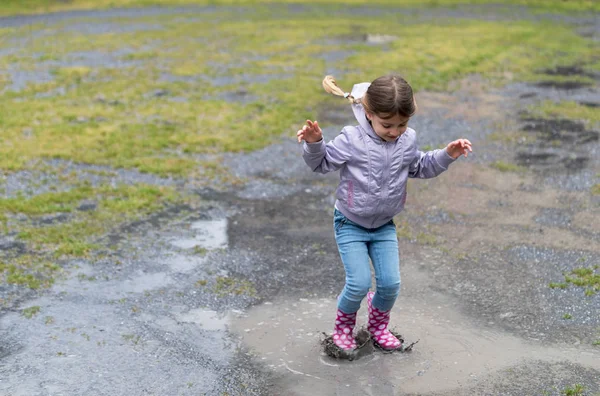 Il bambino che gioca in una pozzanghera — Foto Stock