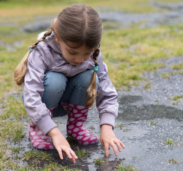 Küçük kız yağmurda oynuyor — Stok fotoğraf