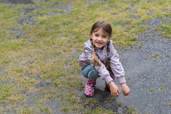 Malá holčička hraje v dešti — Stock fotografie