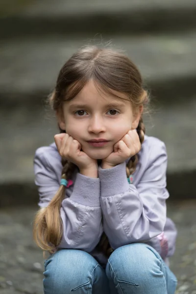 Child sitting on stairs outdoors — Stock Photo, Image