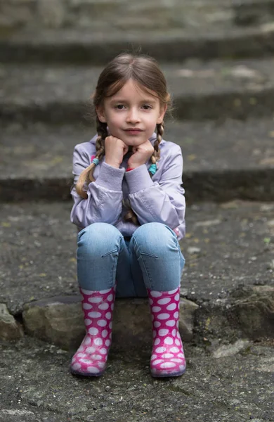 Child sitting on stairs outdoors — Stock Photo, Image