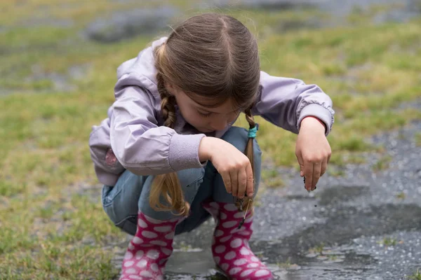 Bir su birikintisine oynayan çocuk