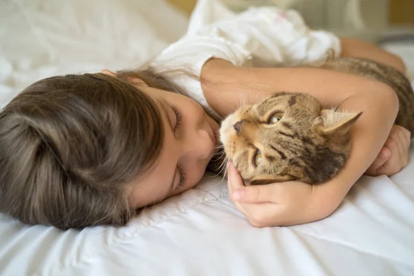 Niño jugando con gato en la cama — Foto de Stock