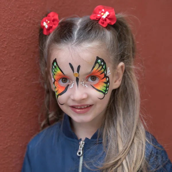 Menina Com Borboleta Pintada Rosto Posando Fundo Parede — Fotografia de Stock