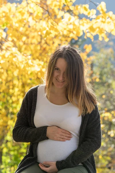 Беременная женщина осенью — стоковое фото