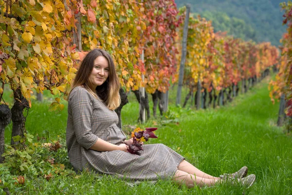 Беременная женщина в осеннем винограднике — стоковое фото