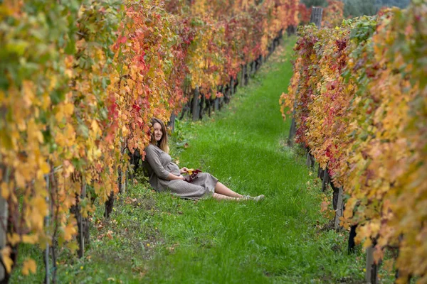 Pregnant woman in autumn vineyard — Stock Photo, Image