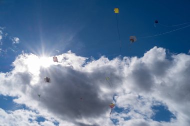 Bulutlu gökyüzünde uçan uçurtmaların alçak açılı görüntüsü