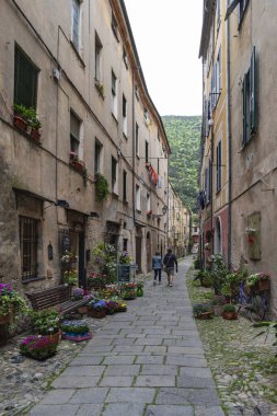 Finale Ligure, İtalya - 24 Nisan 2018: İtalya 'nın Liguria bölgesindeki Savona Eyaleti' nin Finalborgo ilindeki ortaçağ köyünde dar bir sokak boyunca görüntüle