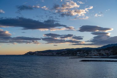 Günbatımında şehir manzaralı renkli bulutlar - Imperia, Liguria, İtalya