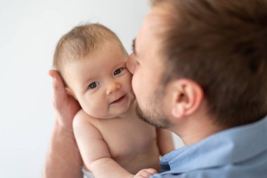Genç baba yeni doğmuş kızını kucağında tutuyor.