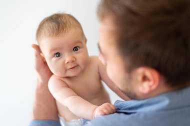 Genç baba yeni doğmuş kızını kucağında tutuyor.