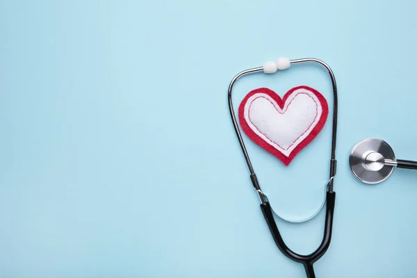 Estetoscopio y corazón sobre fondo azul. Salud, medicina — Foto de Stock
