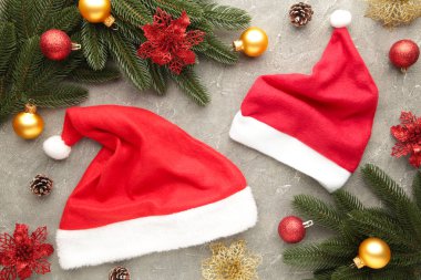 İki Noel Baba kırmızı şapka ve gri arka planda süsleme. Noel süslemesi.