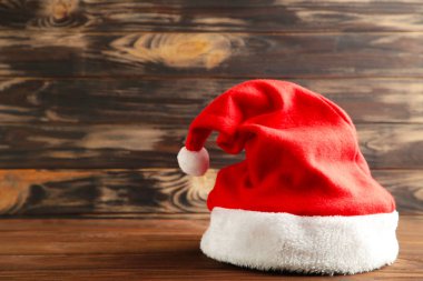 Küçük Noel Baba kahverengi ahşap arka planda kırmızı şapka